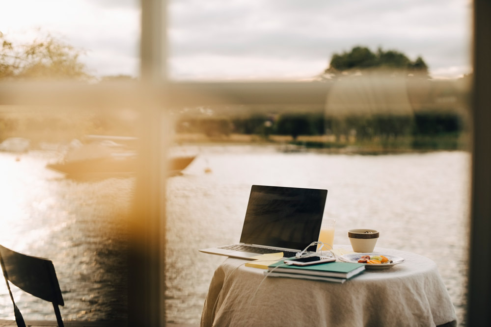 Laptop står på ett bord med en sjö i bakgrunden