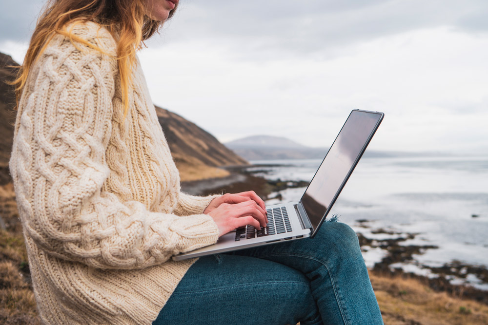 Kvinna som jobbar med sin laptop utomhus